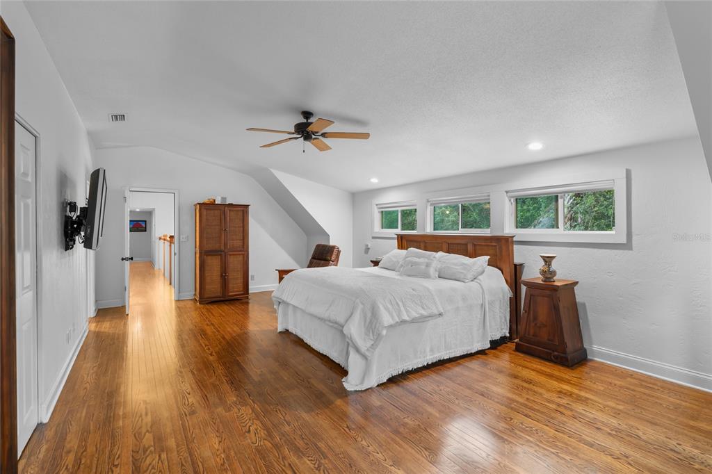 120 Beach Street Ponce Inlet, FL 32127 - Photo 43 of 91 a spacious bedroom with a bed and a chandelier