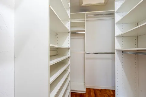 a view of walk in closet with empty racks