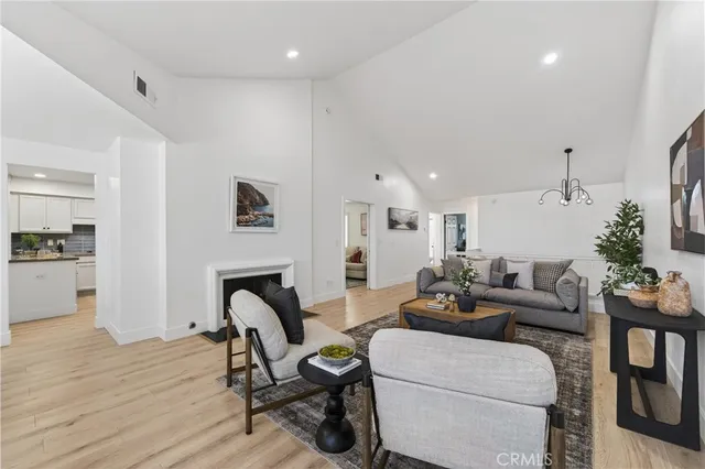 a living room with furniture a fireplace and kitchen view
