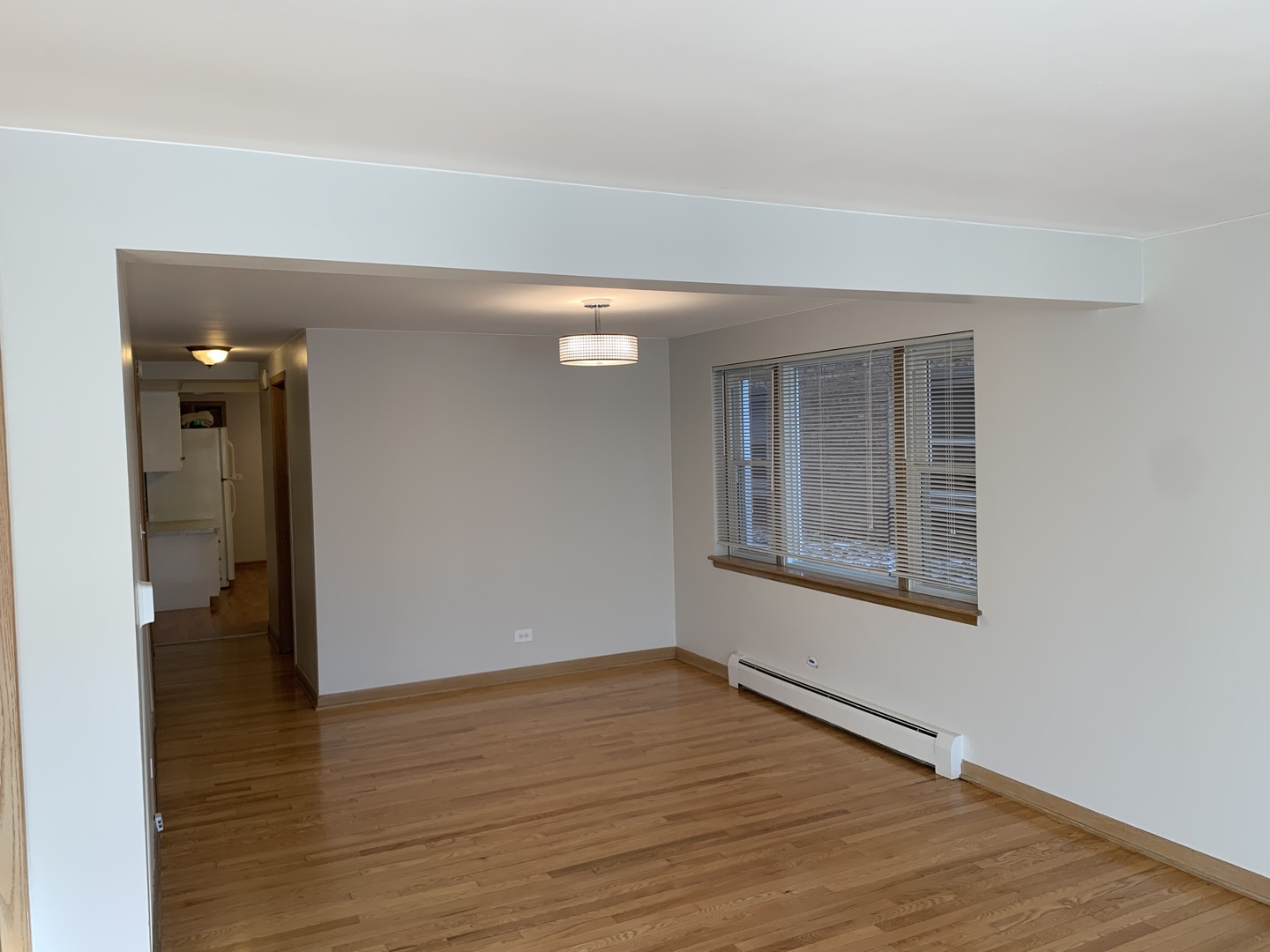 5415 North Monitor Avenue, Unit G Chicago, IL 60630 - Photo 4 of 12 a view of an empty room with wooden floor and a window