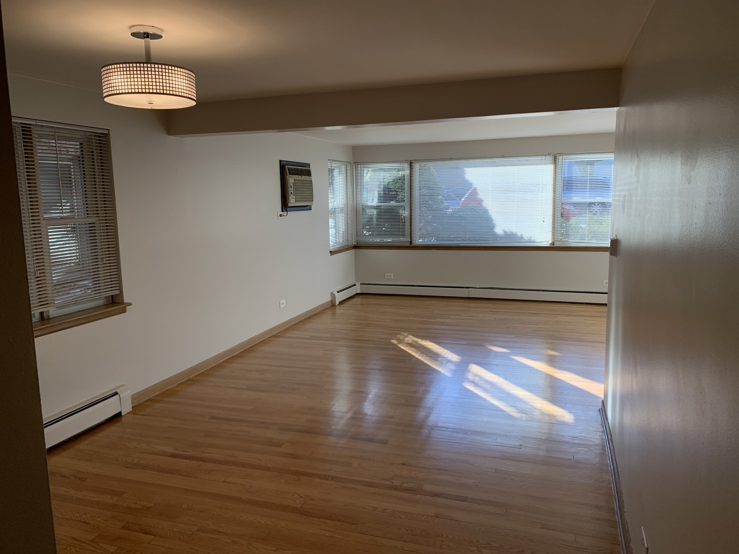 5415 North Monitor Avenue, Unit G Chicago, IL 60630 - Photo 7 of 12 a view of empty room with wooden floor and fan