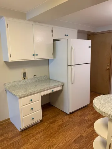 a kitchen with a refrigerator sink and cabinets