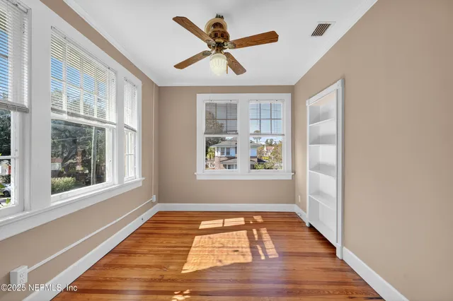 a view of an empty room with closet and a window