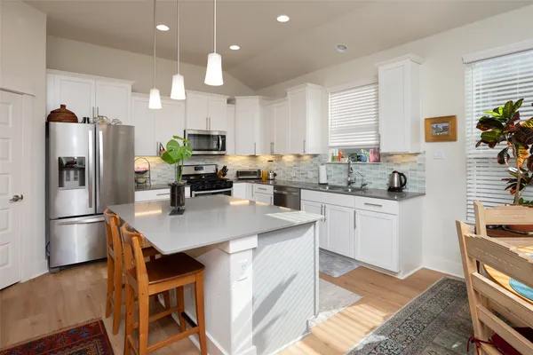 a kitchen with kitchen island a refrigerator stove and microwave
