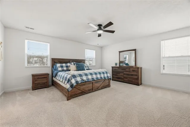 a bedroom with a bed next to a window and a chandelier