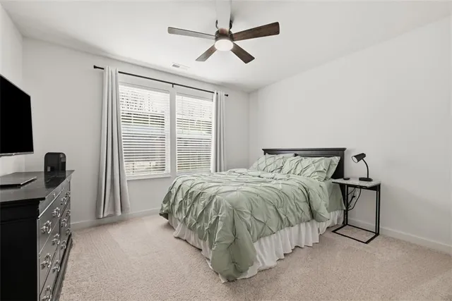 a bed sitting in a spacious bedroom next to a window