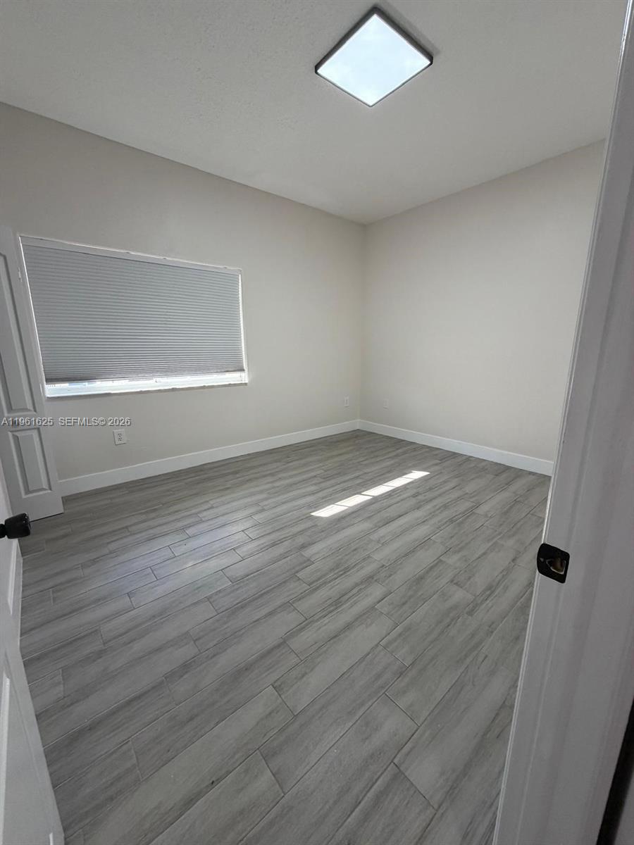 5521 Southwest 158th Court Miami, FL 33185 - Photo 11 of 23 a view of an empty room with wooden floor