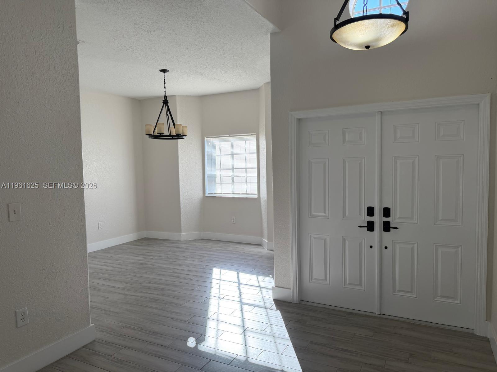 5521 Southwest 158th Court Miami, FL 33185 - Photo 4 of 23 wooden floor in an empty room with a window