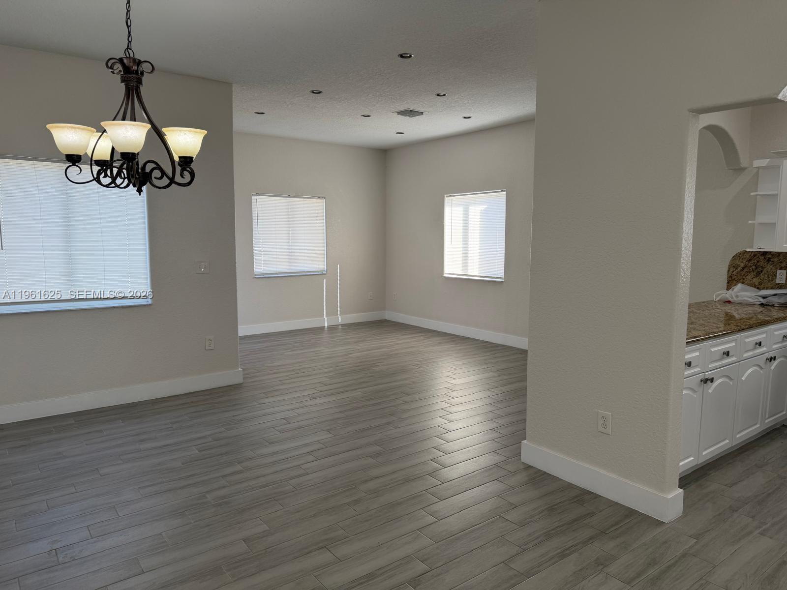 5521 Southwest 158th Court Miami, FL 33185 - Photo 5 of 23 a view of a room with wooden floor a ceiling fan and windows