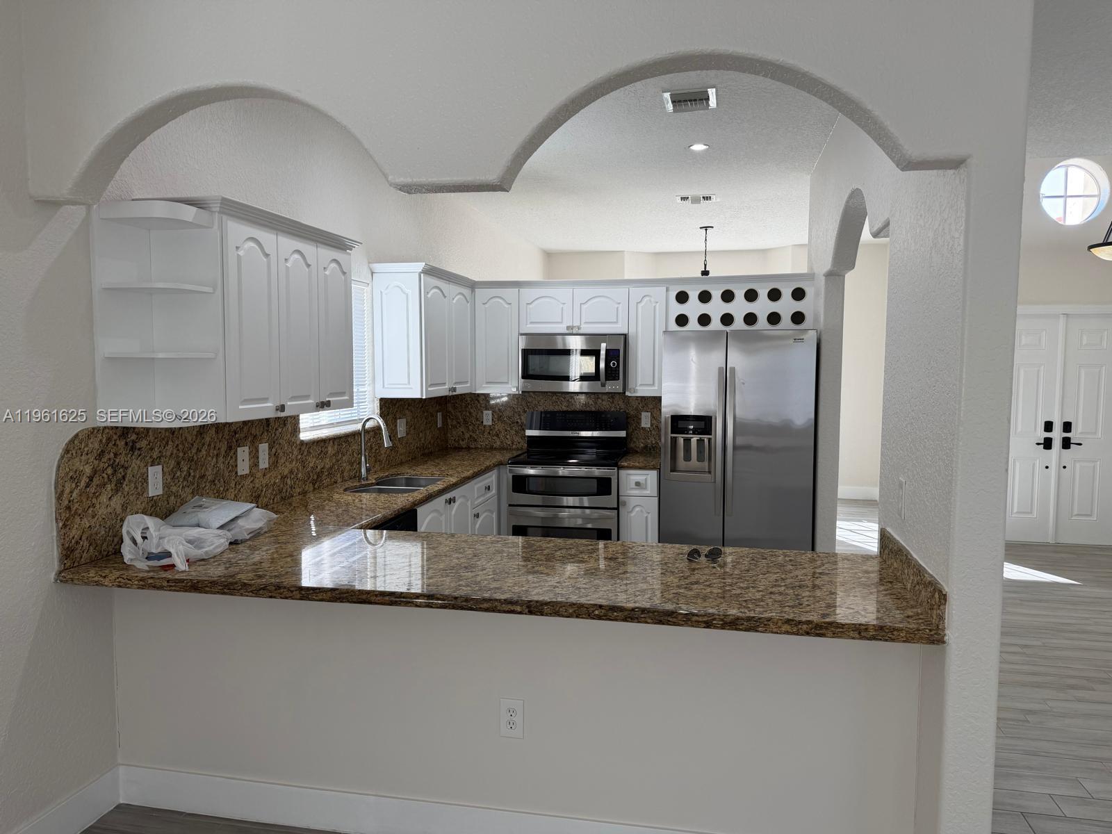 5521 Southwest 158th Court Miami, FL 33185 - Photo 7 of 23 a kitchen with stainless steel appliances granite countertop a sink a stove and refrigerator