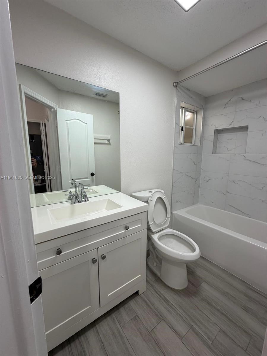 5521 Southwest 158th Court Miami, FL 33185 - Photo 10 of 23 a bathroom with a sink a toilet a mirror a bathtub and shower