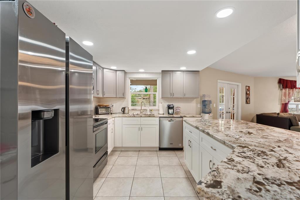 7466 Apache Trail Spring Hill, FL 34606 - Photo 15 of 27 a kitchen with a sink stainless steel appliances and cabinets