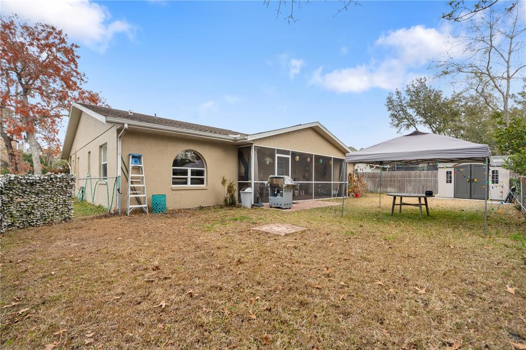 7466 Apache Trail Spring Hill, FL 34606 - Photo 5 of 27 a front view of a house with a garden and yard