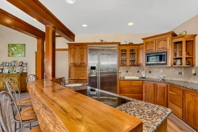 a large kitchen with kitchen island granite countertop a sink and cabinets