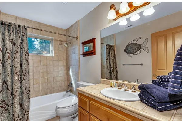 a bathroom with a granite countertop sink mirror vanity and toilet