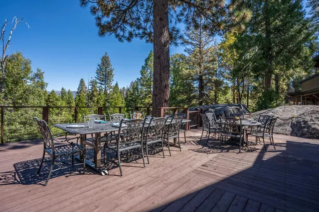 a view of a patio with table and chairs with wooden floor and fence
