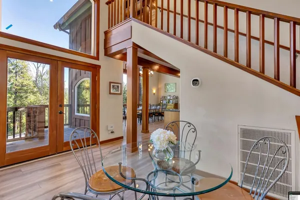 a dining room with wooden floor a glass table and chairs