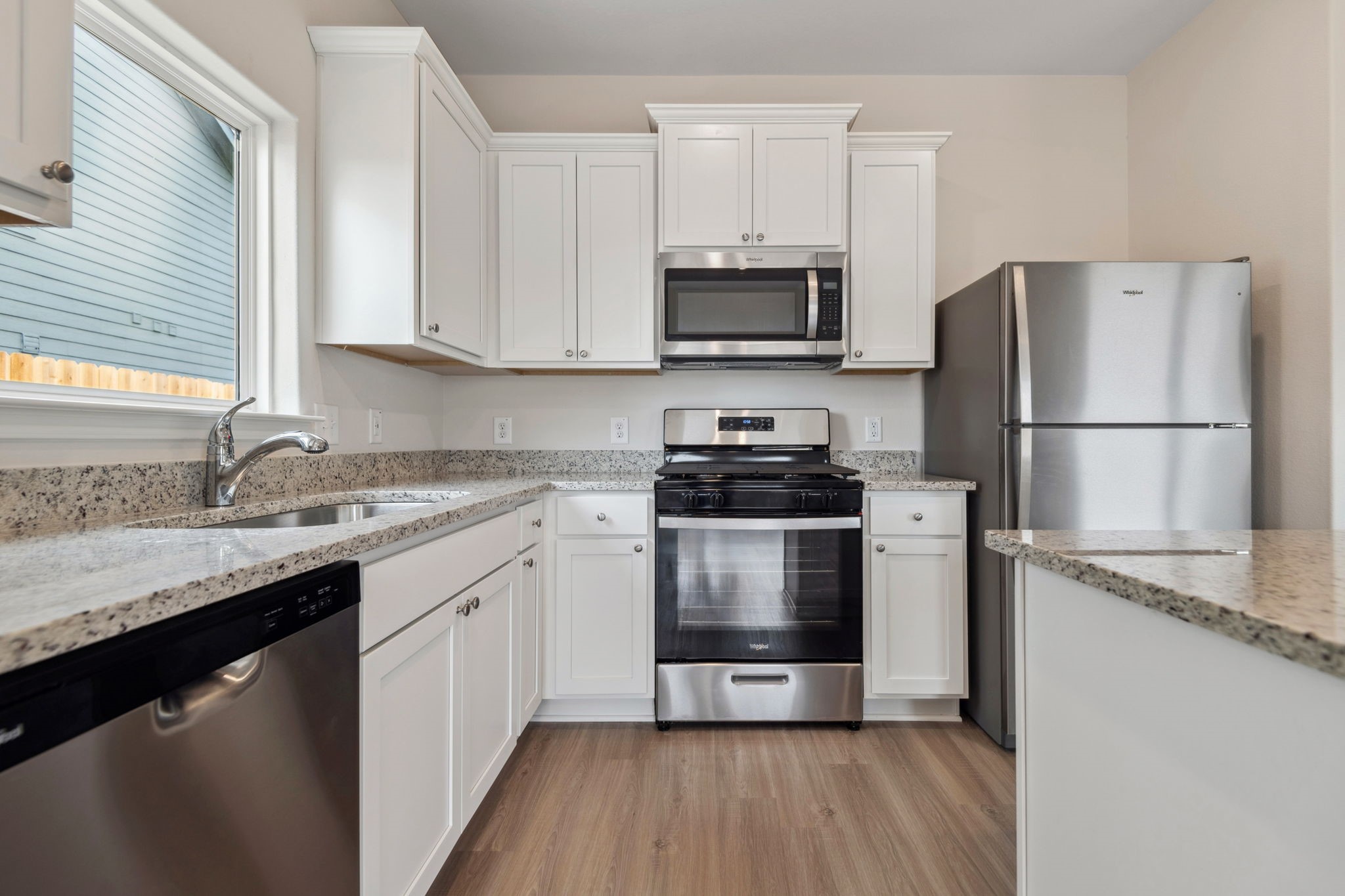 356 Fastboy Lane Waller, TX 77484 - Photo 14 of 23 a kitchen with a sink a refrigerator and white cabinets