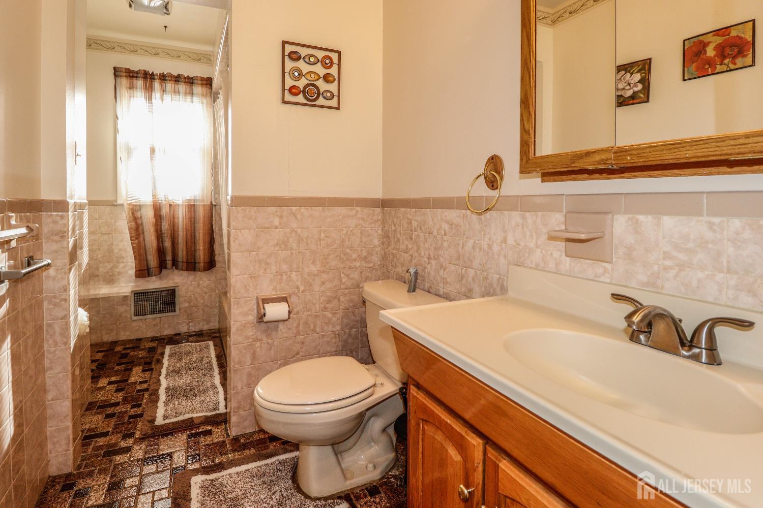 37 Patrick Street Carteret, NJ 07008 - Photo 22 of 30 a bathroom with a sink a toilet and a mirror