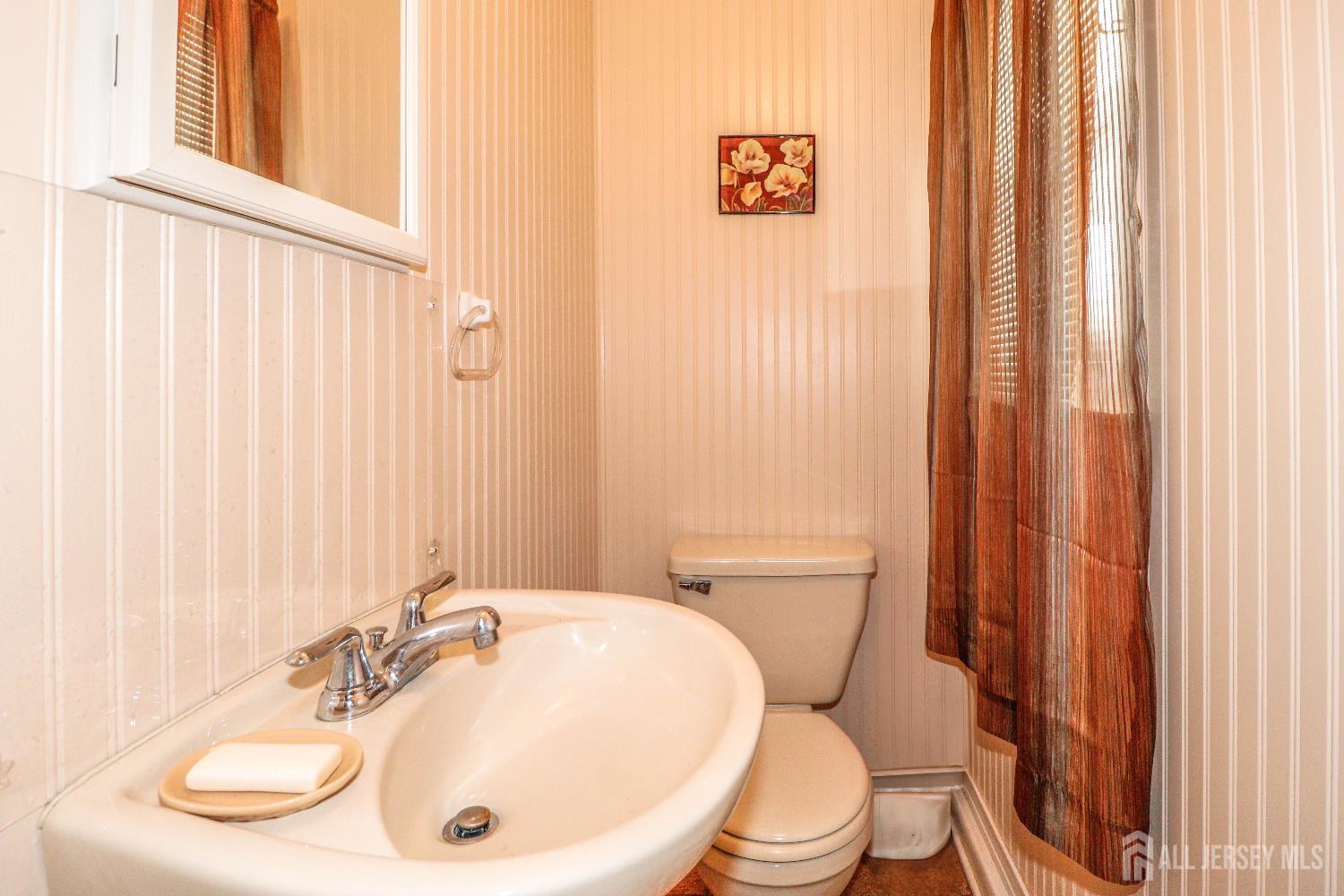 37 Patrick Street Carteret, NJ 07008 - Photo 10 of 30 a bathroom with a sink a toilet and shower curtain