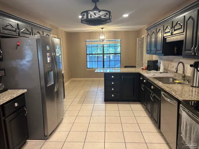 a large kitchen with a large counter top appliances and cabinets