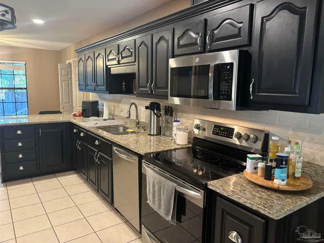 a kitchen with granite countertop stainless steel appliances and sink