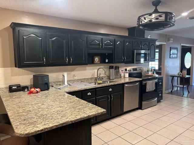 a kitchen with a sink refrigerator and cabinets