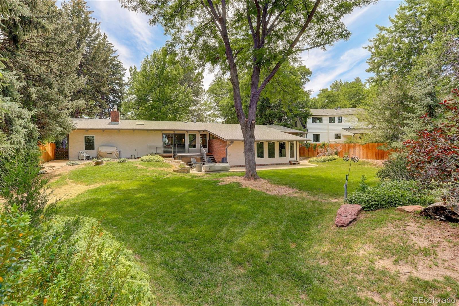 4595 West Lakeridge Road Denver, CO 80219 - Photo 29 of 50 a front view of a house with a yard and trees