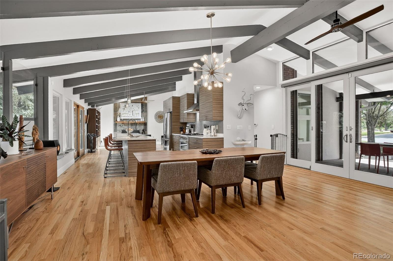 4595 West Lakeridge Road Denver, CO 80219 - Photo 7 of 50 a dining room with wooden floor a chandelier a wooden table and chairs