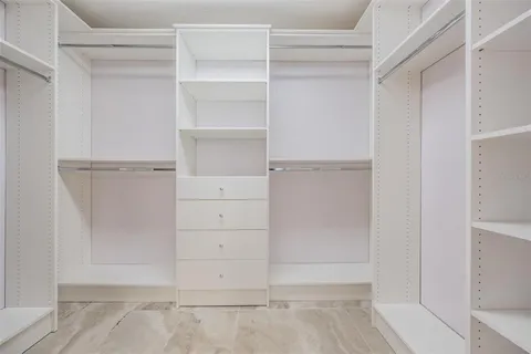 a view of walk in closet with empty racks