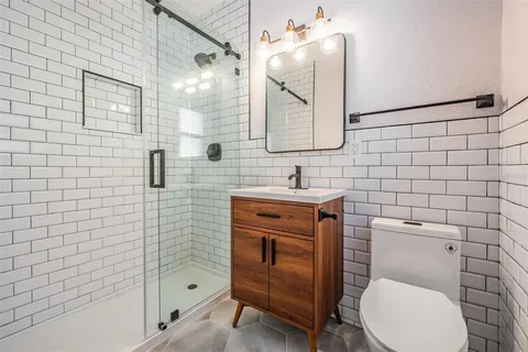 a bathroom with a toilet sink vanity and mirror