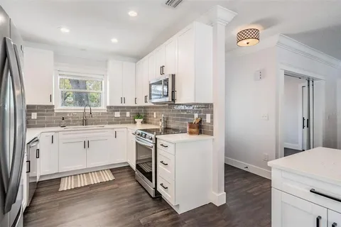 a kitchen with white cabinets and white appliances