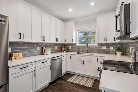 a kitchen with stainless steel appliances granite countertop a sink a stove and cabinets