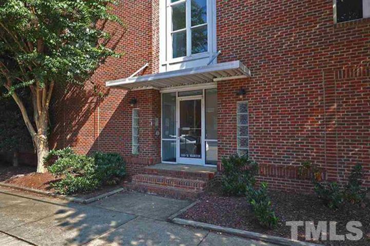 320 West Martin Street, Unit 204 Raleigh, NC 27601 - Photo 1 of 17 a view of a brick house with a large windows and flower plants