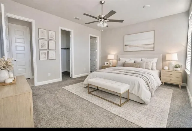 a bedroom with a large bed lamps and a chandelier