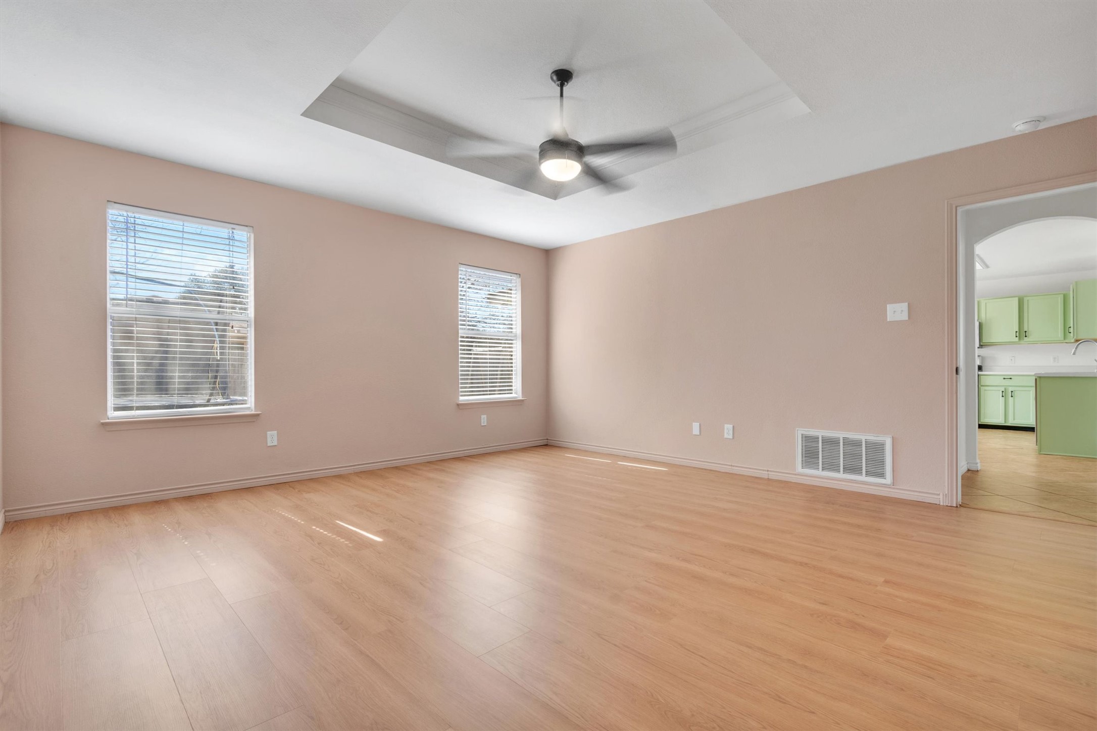 100 Madisons Way Buda, TX 78610 - Photo 17 of 30 Unfurnished room with a raised ceiling, light wood-style floors, ceiling fan, and arched walkways