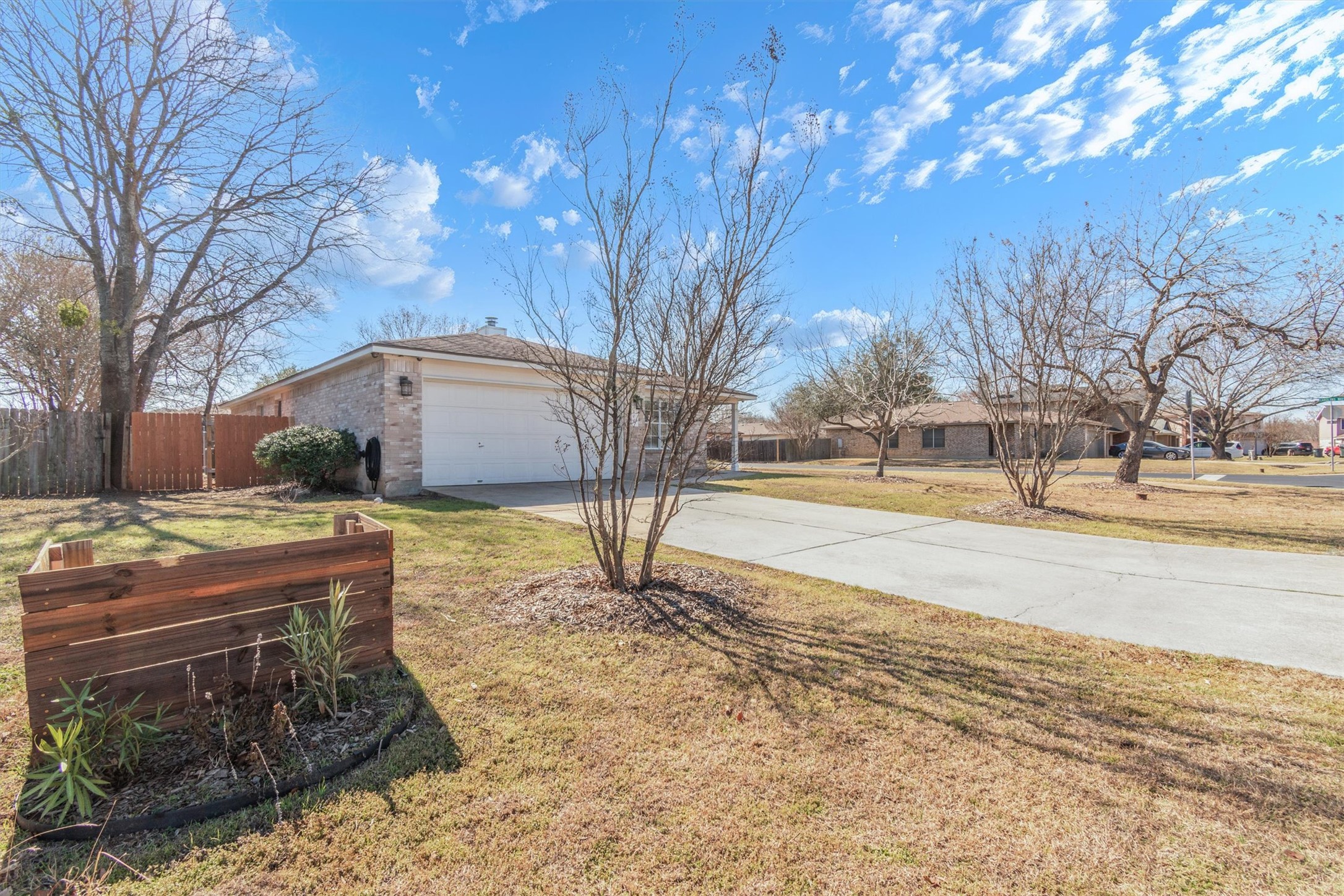 100 Madisons Way Buda, TX 78610 - Photo 2 of 30 View of yard featuring concrete driveway, a garage, and a residential view
