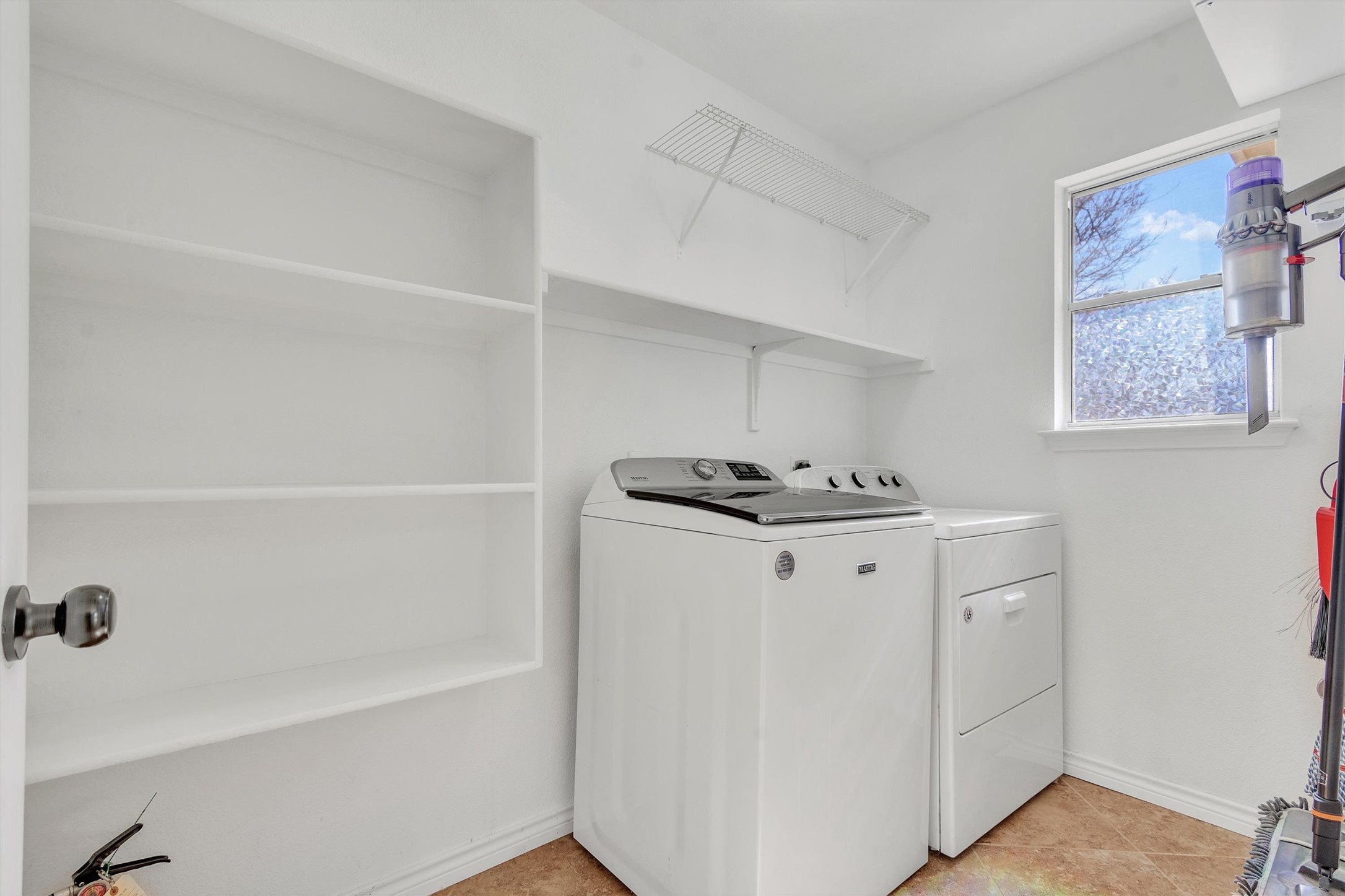 100 Madisons Way Buda, TX 78610 - Photo 24 of 30 Laundry area with washer and dryer and light tile patterned floors