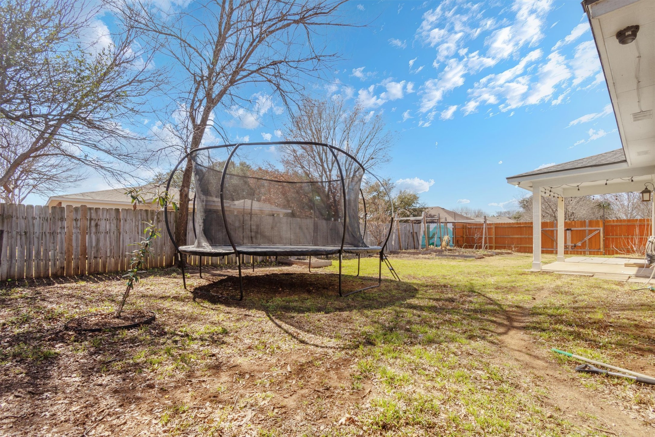 100 Madisons Way Buda, TX 78610 - Photo 27 of 30 Fenced backyard with a trampoline and a patio area