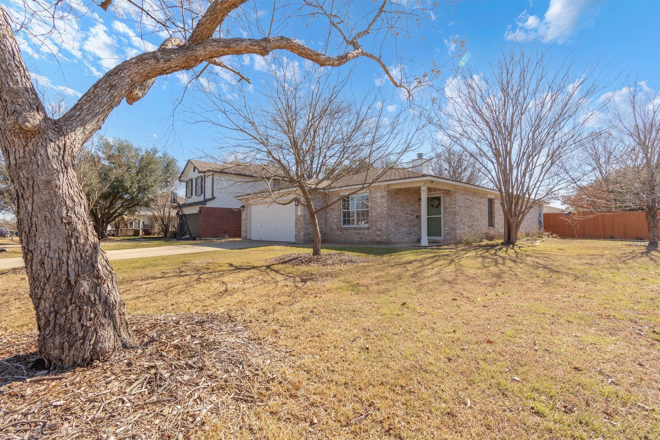 100 Madisons Way Buda, TX 78610 - Photo 3 of 30 View of front facade featuring brick siding, concrete driveway, and a garage