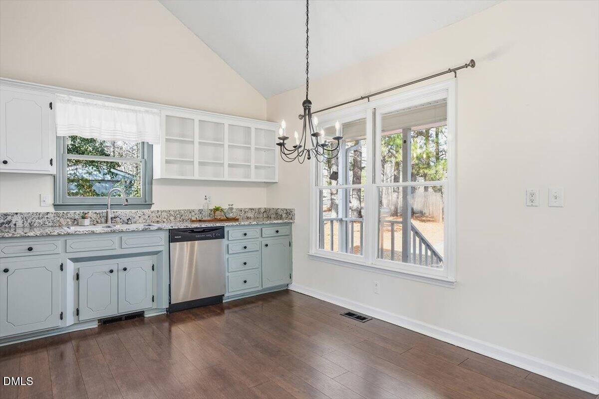 1334 Langdon Road Angier, NC 27501 - Photo 26 of 36 a kitchen with granite countertop a stove a sink and white cabinets with wooden floor