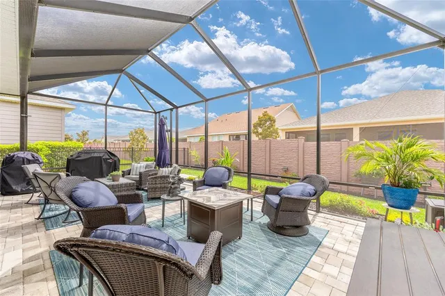 a living room with patio furniture and a potted plant