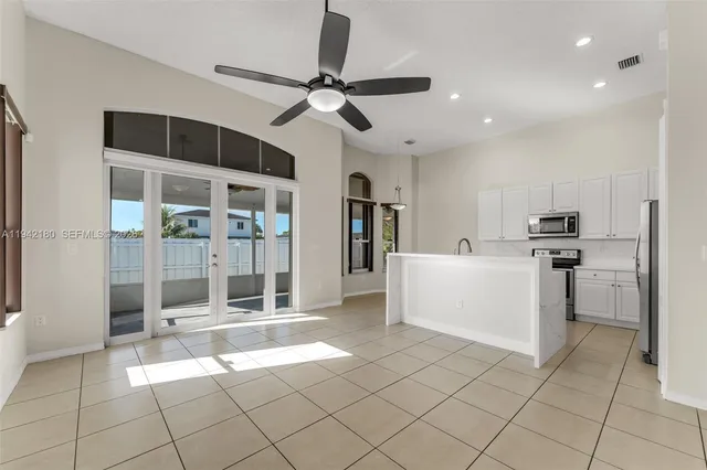 a open kitchen with white cabinets and white stainless steel appliances