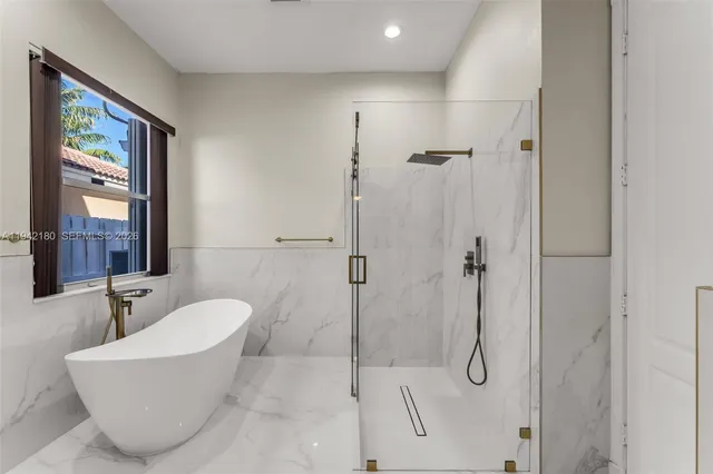 a bathroom with a white tub shower and sink