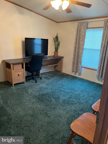 a bedroom with a bed and a flat tv screen on dresser