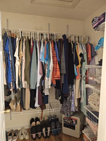 a view of walk in closet with clothes and shoes