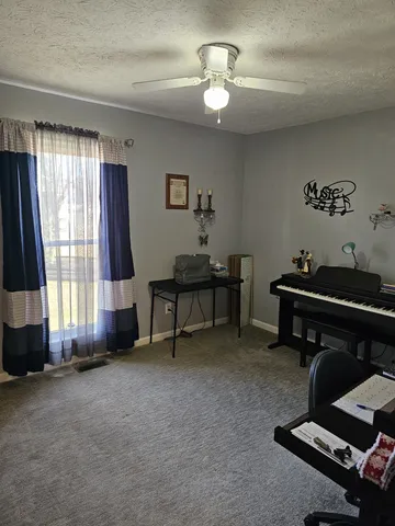 a view of a workspace with furniture and a window