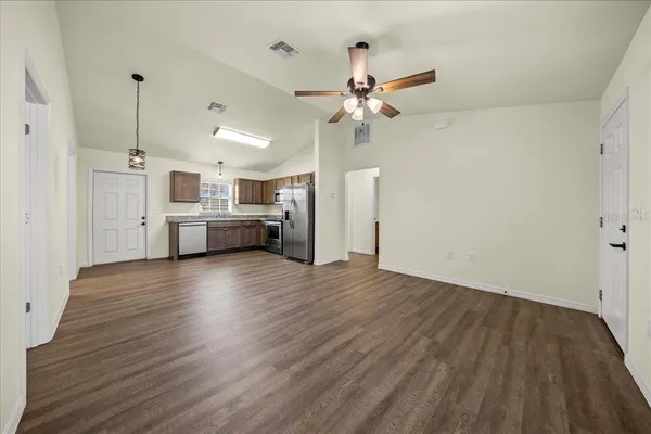 a kitchen with granite countertop stainless steel appliances a refrigerator sink and microwave