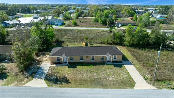 an aerial view of a house with a yard lake view and large trees