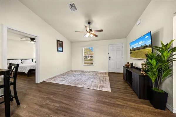 a living room with stainless steel appliances kitchen island granite countertop furniture and a flat screen tv